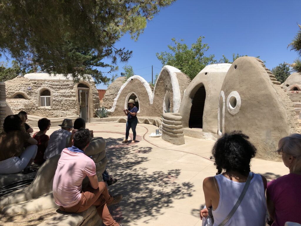 Visitors attending a CalEarth Open House tour among SuperAdobe buildings in Hesperia, California