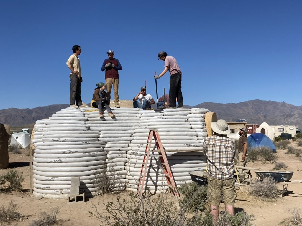 Earthbag structure under construction during a natural building workshop.